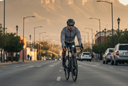Ciclista urbano con casco y luces pedaleando al amanecer en Monterrey, ejemplo de seguridad para empezar en el ciclismo como deporte
