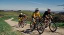 Ciclistas practicando gravel bike en grupo por sendero rural con cascos y ropa de ciclismo