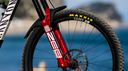 Ciclista en sendero forestal con suspensión RockShox en bicicleta de montaña, disponible en México con VeloStore