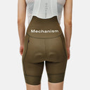 Bib shorts Mechanism de Pas Normal Studios en color oliva con tirantes blancos, vistos desde la espalda en Velo Store Mx