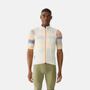 Ciclista con chaleco Velocio LUXE Ultralight blanco, resistente al viento y transpirable, sobre jersey de ciclismo.
