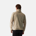 Vista trasera de la chaqueta beige Velocio Ultrapack para caballero, ligera y transpirable, ideal para ciclismo.