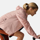Ciclista mujer usando chaqueta rosa Velocio Ultrapack de Velo Store Mx, ligera y resistente al viento para ciclismo.