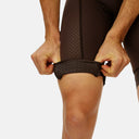 Ciclista ajustando el elástico con patrón de silicón en el culotte Velo Store Mx Pas Normal Studios color café
