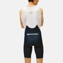 Ciclista de espaldas usando culotte con tirantes Velo Store Mx Pas Normal Studios Mechanism en color negro y blanco