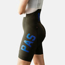 Culotte con tirantes Pas Normal Studios Mechanism Pro para mujer en color verde oliva con logo azul, ajuste aerodinámico.