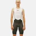 Ciclista con culotte con tirantes Pas Normal Studios Mechanism verde oliva y camiseta interior blanca de malla