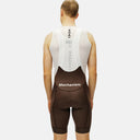 Ciclista de espaldas usando culotte con tirantes marrón Pas Normal Studios Mechanism de Velo Store Mx con malla blanca