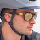 Gafas de sol Velo Store Mx KOO California con lentes espejo y montura negra, usadas por un ciclista con casco gris.