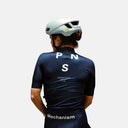 Ciclista con jersey azul marino Pas Normal Studios Mechanism de Velo Store Mx, ajuste aerodinámico y casco gris
