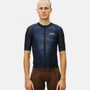 Ciclista vistiendo jersey de ciclismo Pas Normal Studios Mechanism azul oscuro con ajuste aerodinámico de carrera