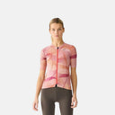 Ciclista con jersey Velocio ONE Artist Series GEO de tonos rosados y diseño geométrico, fabricado en poliéster reciclado