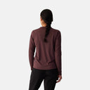 Vista trasera de mujer con jersey de ciclismo Velocio Delta TRAIL color burdeos de manga larga en Velo Store Mx
