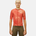 Ciclista vistiendo jersey de ciclismo Pas Normal Studios Mechanism en color naranja con estampado sutil y ajuste race-fit