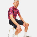 Ciclista con jersey Pas Normal Studios de estampado floral rosa y negro, combinado con culotte negro, en Velo Store Mx.