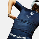 Ciclista con jersey Velo Store Mx Pas Normal Studios Mechanism azul marino de ajuste aerodinámico y bolsillos traseros