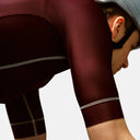 Ciclista con maillot Pas Normal Studios Mechanism color burdeos de ajuste aerodinámico en Velo Store Mx