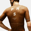 Ciclista con maillot marrón Pas Normal Studios Mechanism de corte aerodinámico y tejido técnico transpirable en Velo Store Mx