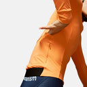 Maillot de ciclismo naranja Pas Normal Studios con bolsillo lateral, ajuste aerodinámico y detalles de Velo Store Mx
