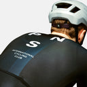 Ciclista con maillot negro Pas Normal Studios Mechanism de Velo Store Mx, ajuste aerodinámico y logo en la espalda.