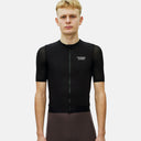 Ciclista vistiendo el maillot negro Pas Normal Studios Essential Light con tejido transpirable de nido de abeja