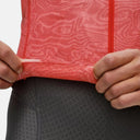 Detalle de maillot de ciclismo Pas Normal Studios Mechanism en rojo con textura y banda elástica en Velo Store Mx