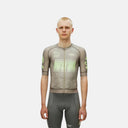 Ciclista con maillot Pas Normal Studios Mechanism en color tierra con estampado topográfico y detalles en verde lima