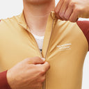 Ciclista ajustando la cremallera del maillot de manga larga Velo Store Mx Pas Normal Studios Mechanism color ocre