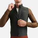 Ciclista con maillot térmico Pas Normal Studios Mechanism en tonos verde oliva y marrón, ajuste aerodinámico pro-fit.