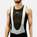 Ciclista vistiendo culote con tirantes negro Pas Normal Studios Mechanism Pro con malla técnica y tirantes blancos