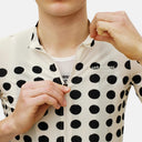 Ciclista vistiendo el jersey Pas Normal Studios Essential en color Dot Bone con estampado de puntos negros.