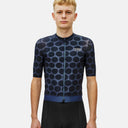 Ciclista vistiendo el jersey Pas Normal Studios Essential en color Dot Dark Navy con estampado de puntos y cremallera.