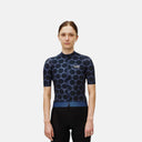 Ciclista con jersey Pas Normal Studios Essential Light en azul marino con estampado de puntos oscuros y ajuste técnico.