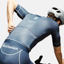 Ciclista con maillot Velo Store Mx Pas Normal Studios Mechanism azul de corte aerodinámico y tejido transpirable